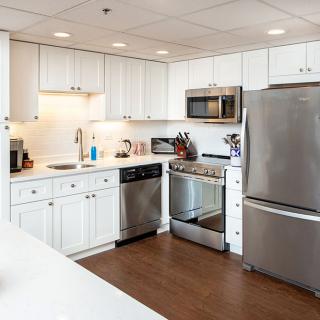 A modern kitchen with white cabinets and stainless steel appliances.