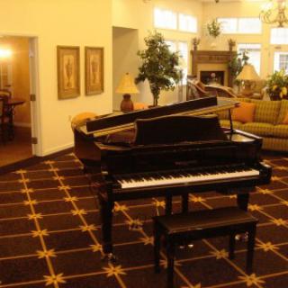 A grand piano in an elegantly furnished living room.
