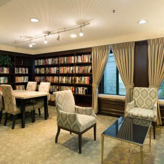 A cozy library with elegant furniture and well-stocked bookshelves.
