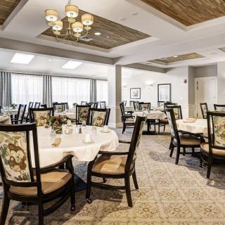 An elegant dining room with neatly arranged tables and chairs, featuring classic interior design elements.