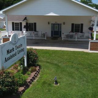 Front view of an assisted living facility with a neatly maintained lawn and welcoming entrance.