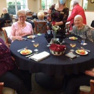 A group of elderly individuals enjoying a meal together at a dining table.