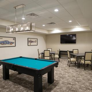 A modern game room featuring a pool table and seating area.