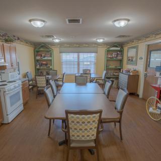 A cozy dining room and kitchen space with a large table surrounded by chairs.
