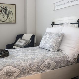 A cozy bedroom with a neatly made bed and stylish decor.