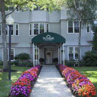 A well-landscaped building entrance with a flower-lined walkway.