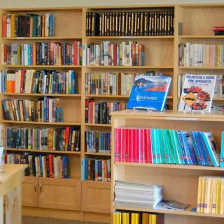 A library interior with books neatly arranged on wooden shelves.