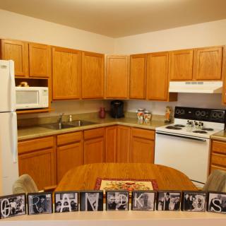 A modern kitchen with wooden cabinets and standard appliances.