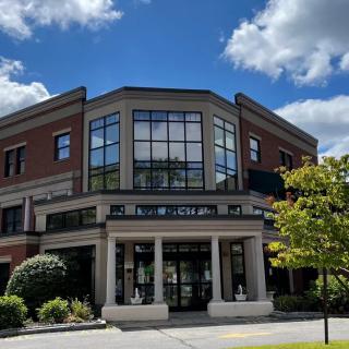 A modern two-story building under a blue sky with clouds.