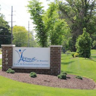 A welcoming sign at the entrance of a facility, surrounded by lush greenery.