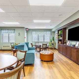 A cozy living room with comfortable seating, a large television, and natural light from the windows.