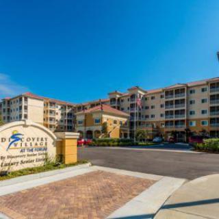 Entrance to a large residential apartment complex with clear signage and multiple stories.