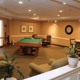 A cozy recreation room featuring a billiards table and comfortable seating.