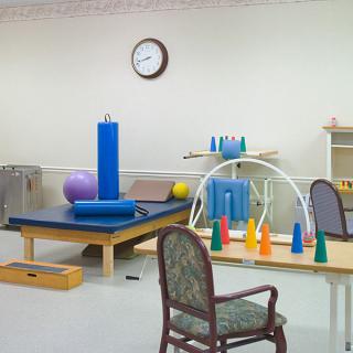 A rehabilitation room equipped with various physical therapy tools and exercise equipment.