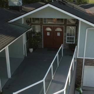 A house entrance with a ramp leading to the front doors.