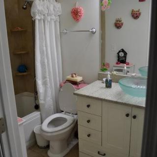 A small, decorated bathroom with a white shower curtain and vanity.