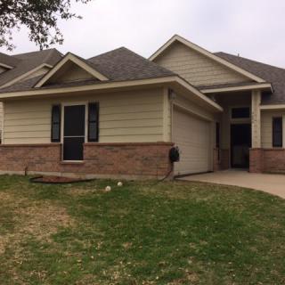A suburban house with a front lawn and driveway.