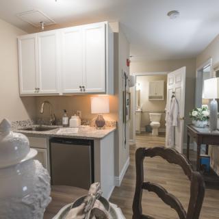 A modern apartment kitchen with white cabinetry and stylish decor.
