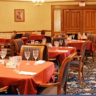 A warmly decorated restaurant dining room with set tables and chairs, ready for guests.