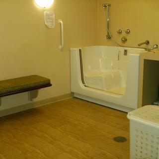 An accessible bathroom with a walk-in bathtub and a bench.