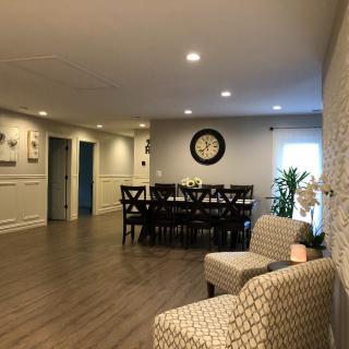 A spacious interior featuring a dining area with wooden floors, elegant furniture, and subtle lighting.