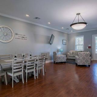 A cozy living and dining area with hardwood flooring, stylish furniture, and a modern chandelier.