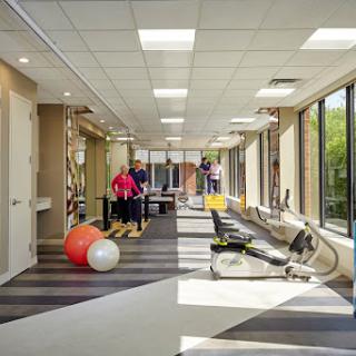 A bright and spacious physical therapy room equipped with various exercise tools for rehabilitation.