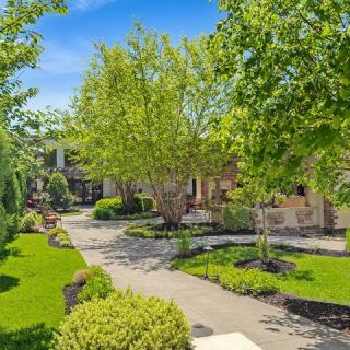 A beautifully landscaped garden with a winding pathway surrounded by lush trees and greenery.