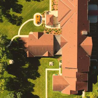 Aerial view of a beautifully landscaped home with lush green surroundings.