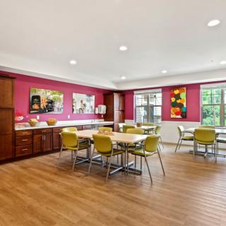 A modern dining area with colorful walls, contemporary furniture, and artwork displayed on the walls.