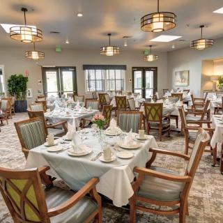 An elegantly set dining room with neatly arranged tables and chairs, ready for guests.