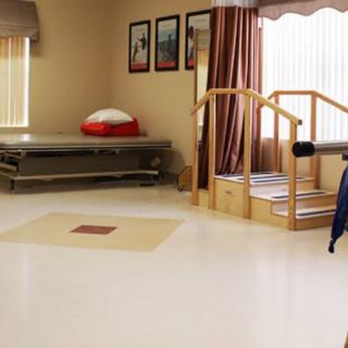 A rehabilitation center therapy room with exercise stairs and a bed.