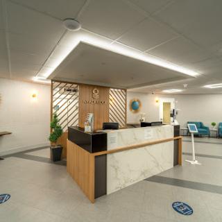 A modern reception area featuring a sleek design with wooden accents and marble surfaces.