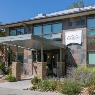 A modern commercial building with a landscaped entrance and an awning.