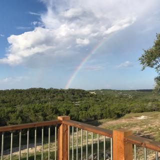A scenic view of a lush green landscape with a rainbow arching across the sky.