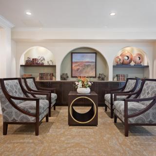 Elegant living room with stylish chairs, a central table, and decorative artwork on display.