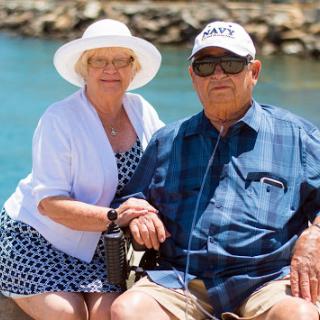 A joyful elderly couple enjoying a sunny day by the beach.