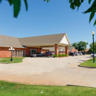 A welcoming hotel entrance surrounded by green landscaping on a sunny day.