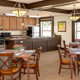 A modern dining area with wooden furniture and an adjacent kitchen.