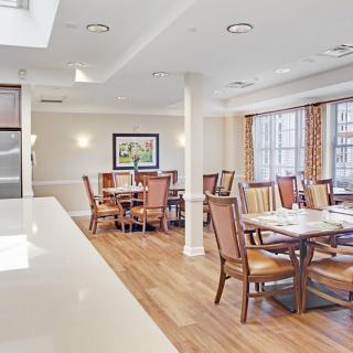 A bright and modern dining room with neatly arranged tables and chairs.