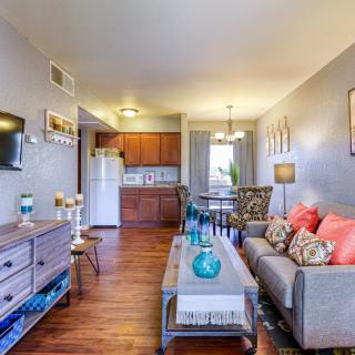 A cozy apartment living room with stylish furniture and a view into the kitchen area.