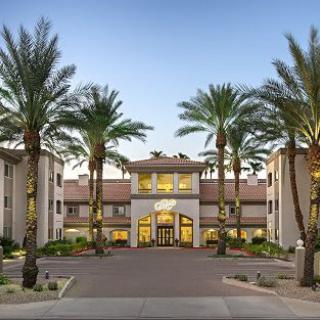 A residential building with palm trees lining the entrance.