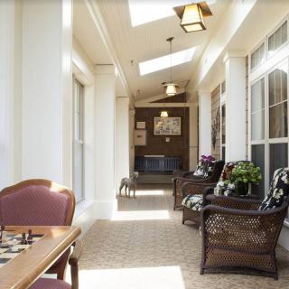 A sunlit hallway with comfortable seating and large windows.