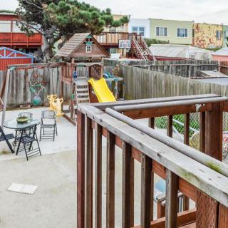 A backyard with a playground slide and outdoor seating area in an urban setting.