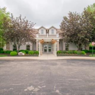 A symmetrical building with a grand entrance, surrounded by well-maintained trees and landscaping.