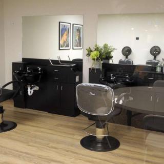 A modern hair salon interior with styling chairs, mirrors, and washing stations.