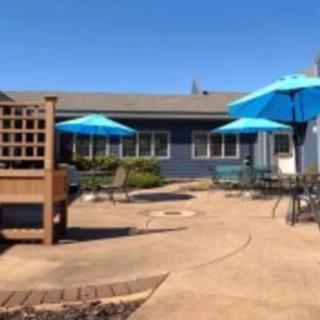 A sunny patio area with blue umbrellas and outdoor furniture.