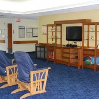 A cozy waiting room with rocking chairs and a television.