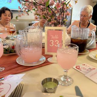 A cheerful gathering with pink lemonade and floral decor.