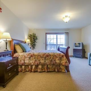 Cozy bedroom with classic furniture and warm lighting.